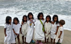 Eight Arhuaco children line up for a photo by the ocean