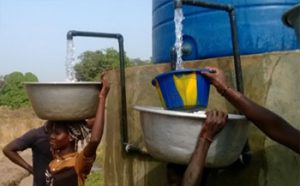 People collect water from a solar-powered clean water pump