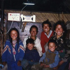 A family smiles under their new solar-powered light source