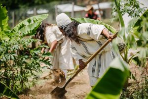 Two Arhuaco community members dig in a garden