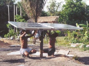 Two people wire a solar panel provided by the Solar Electric Light Fund (SELF)