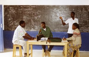 Four people study and discuss in a classroom in Tanzania