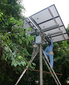 Two people install a solar array in Tanzania