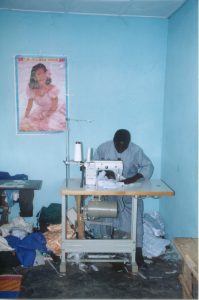 A person sits at a desk sewing textiles