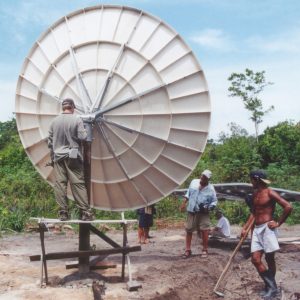 A group of people work on installing a satellite in a Brazilian community
