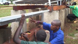 People work on constructing a solar array in Burundi