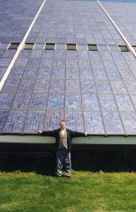 Man leans against a large solar array in China