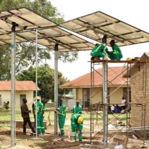 A group of people set up solar panels in a small African village
