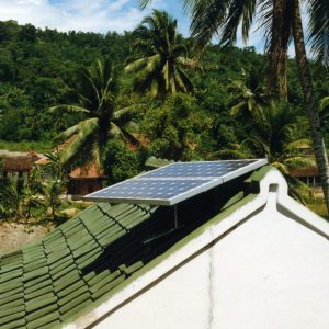 A panel sits on a rooftop in an Indonesian town in the jungle