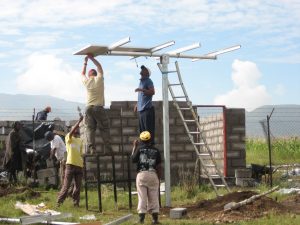 Team of people work to set up a solar panel from the Solar Electric Light Fund (SELF) in Lesotho