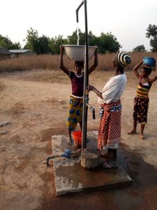 A woman and children collect clean water from a solar water pump
