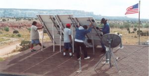 People set up solar panels for the Native American Access to Technology Program in the Navajo Nation