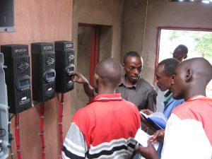 A technician in Kigutu, Burundi teaches others how a new energy system works