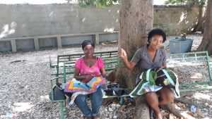 Two women in Haiti stitch quilts for the Peace Quilts program