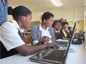 Students work on computers at a school powered by solar energy