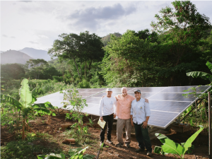 Solar energy specialists stand in front of a newly installed solar array in Colombia