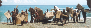 People in the Soloman Islands stand by the ocean with cardboard signs