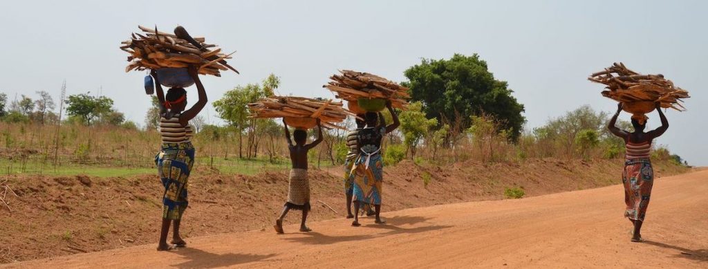 Four women and a child walk down the road in Benin; SELF works in this community and others in order to mitigate climate change and poverty in Africa