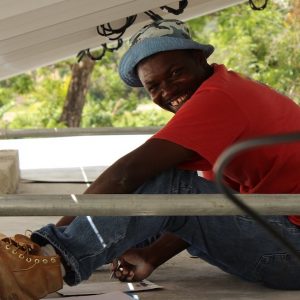 Solar technician smiles as he sets up a solar panel in Haiti