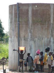 Children gather around a water tank in Benin
