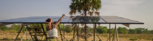Woman in Benin cleans solar panels which provide energy for clean water and agriculture