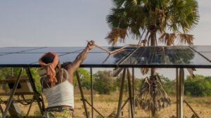 Woman washes solar panels, which can be a solution to climate change and poverty in Africa